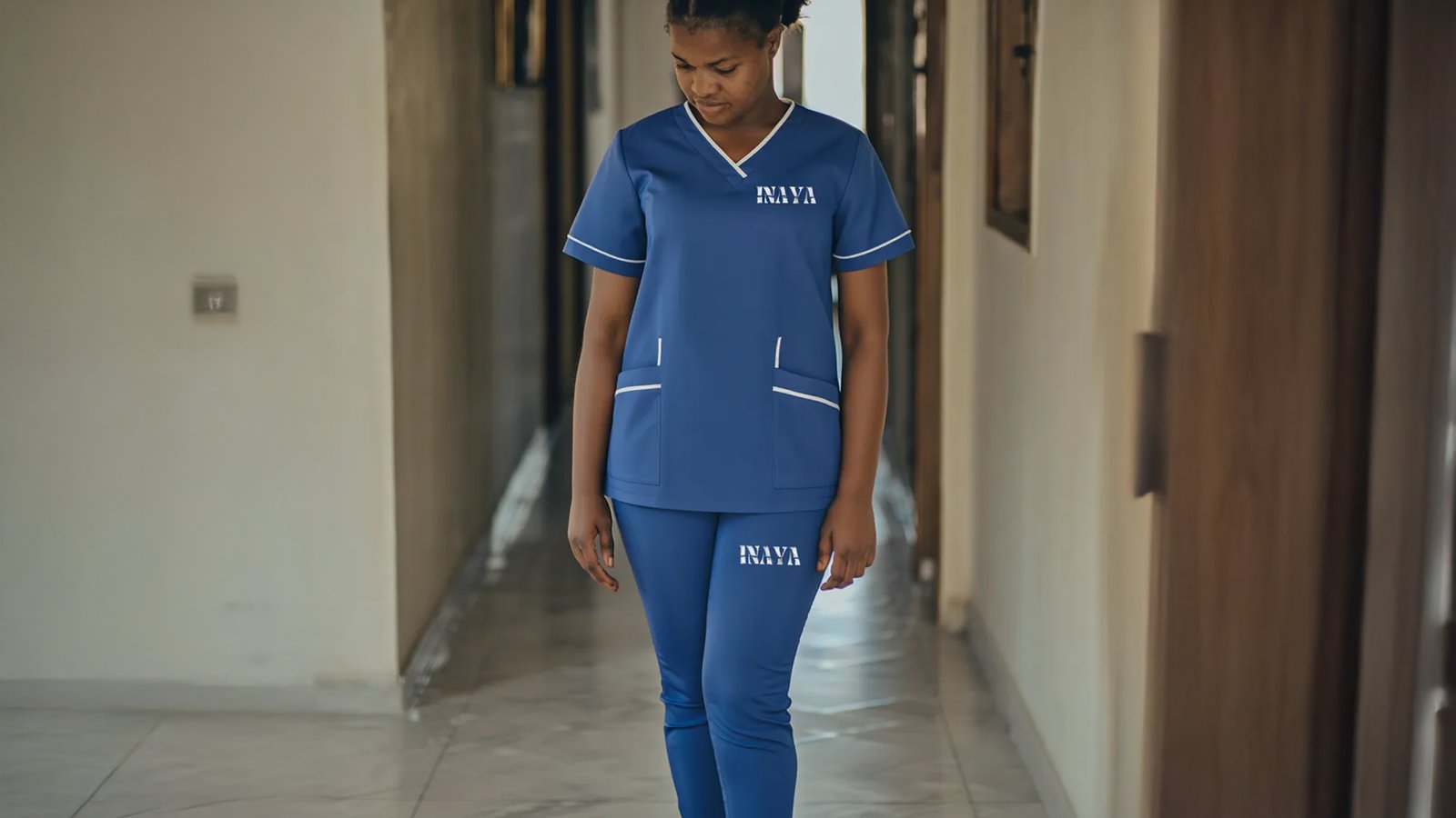 INAYA uniform in a hallway