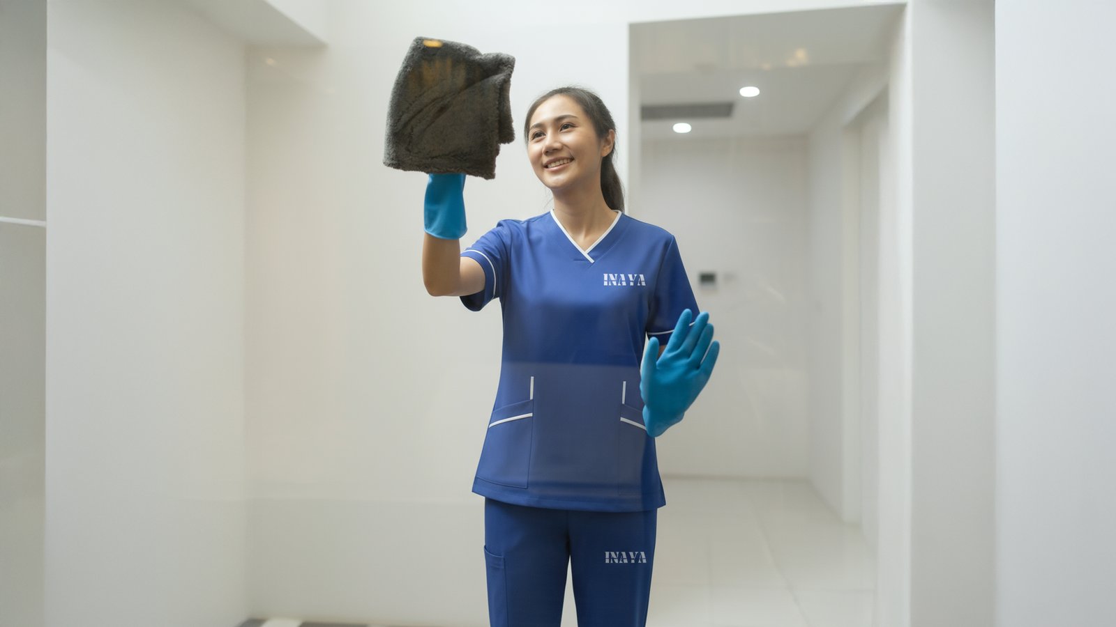 Cleaning a glass partition in an INAYA uniform