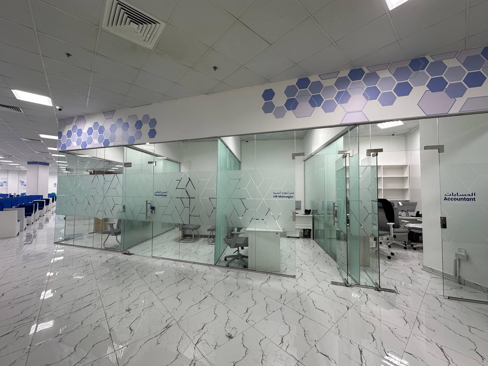 Glass-partitioned rooms inside the INAYA Ajman office