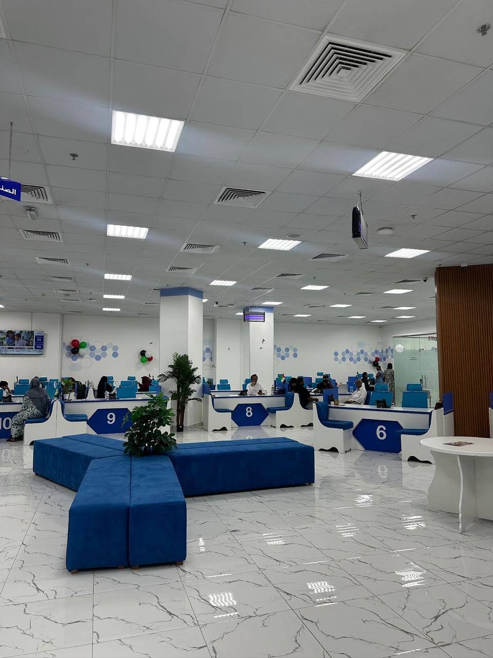 INAYA Ajman customer-service hall and blue waiting benches