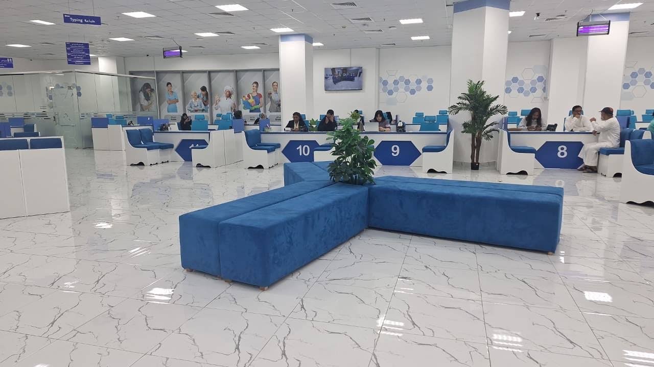 INAYA Ajman customer-service hall and numbered desks